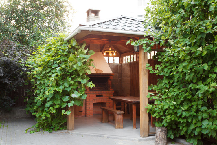 18 Garden Gazebo Ideas for an Outdoor Shelter from the Sun 9 a wooden gazebo covering a stone pizza oven