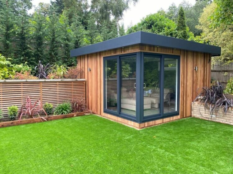a modern, cube-shaped garden office in the corner of a garden