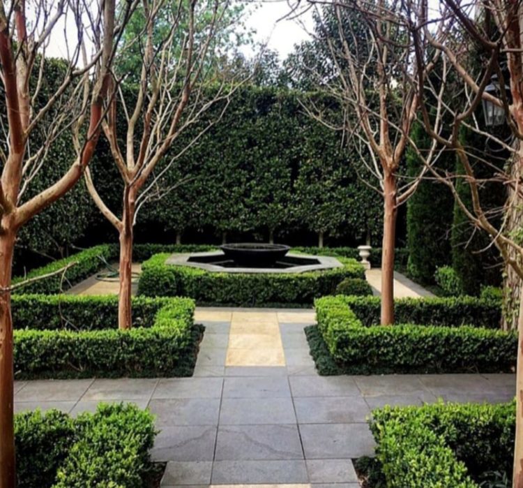 a symmetrical garden with paved flooring and shrubbery inspired by formal French gardens 