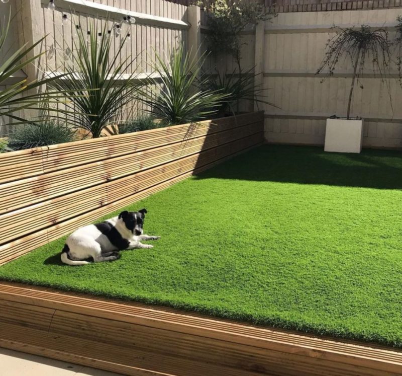 a raised lawn with a wooden boundary and a matching wooden planter at one edge