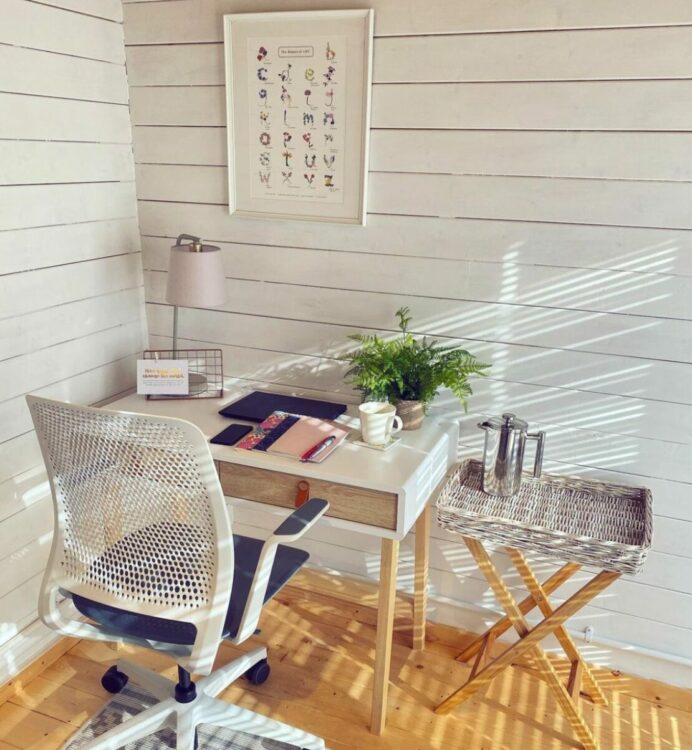 a garden office interior painted white, with a desk