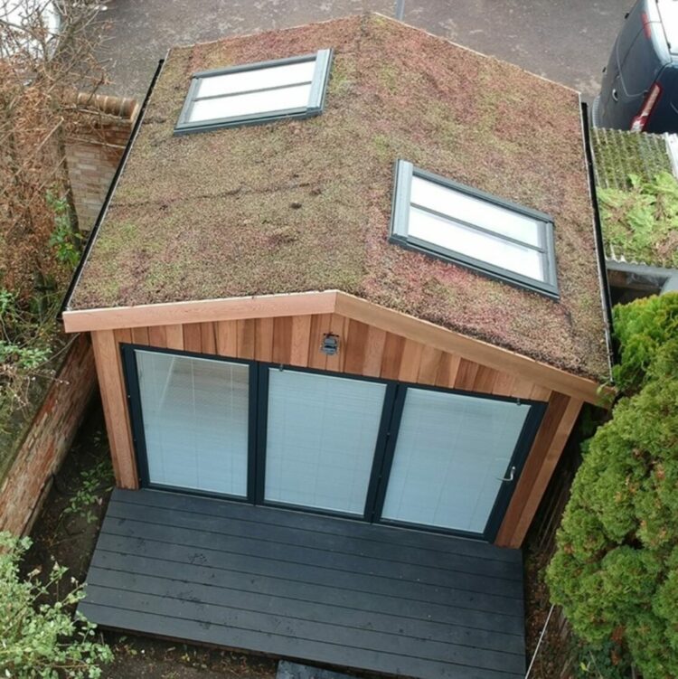 a large garden office with folding glass doors and roof windows