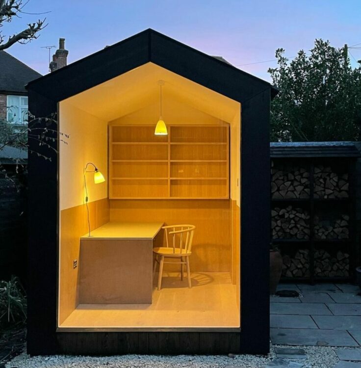 a compact garden office with one side made entirely of glass
