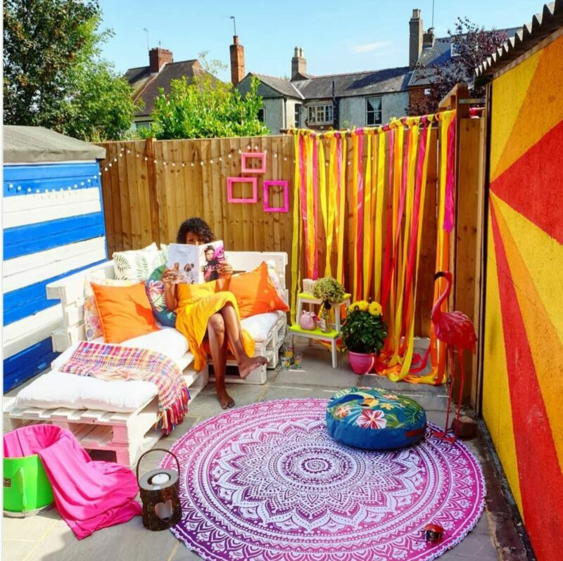 a courtyard decorated with vibrant textiles in a bright, boho style